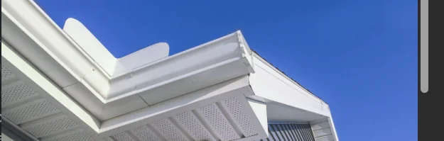Daytime closeup of an open soffit, showing the flat perforated panel fully visible under the eave
