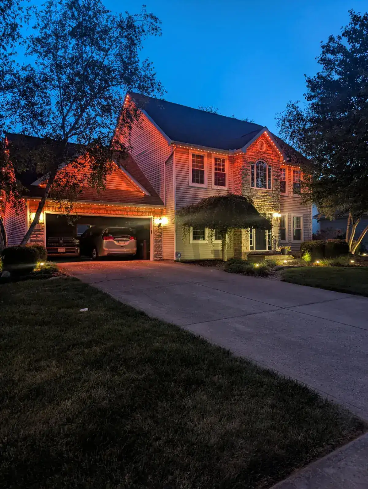 Orange permanent accent lights on colonial home at dusk in Columbus Ohio