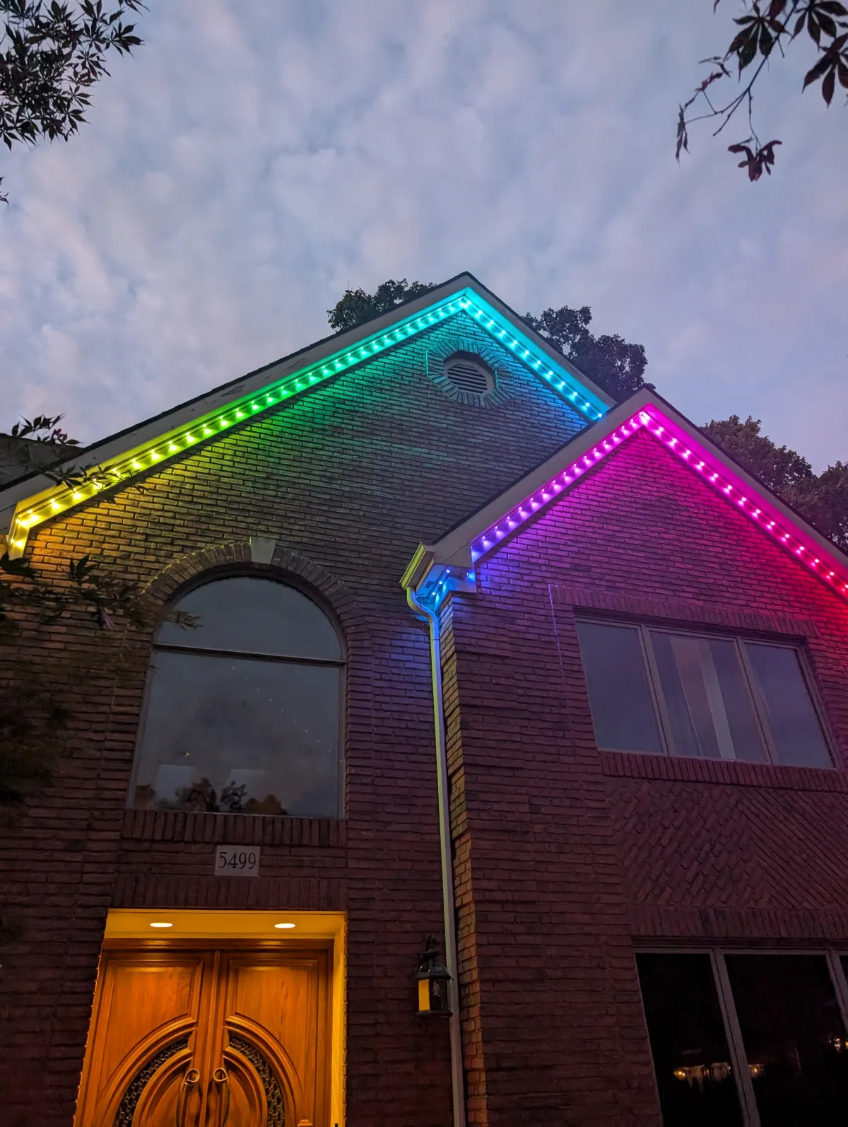 Rainbow permanent lights on tall brick home at dusk in Columbus Ohio
