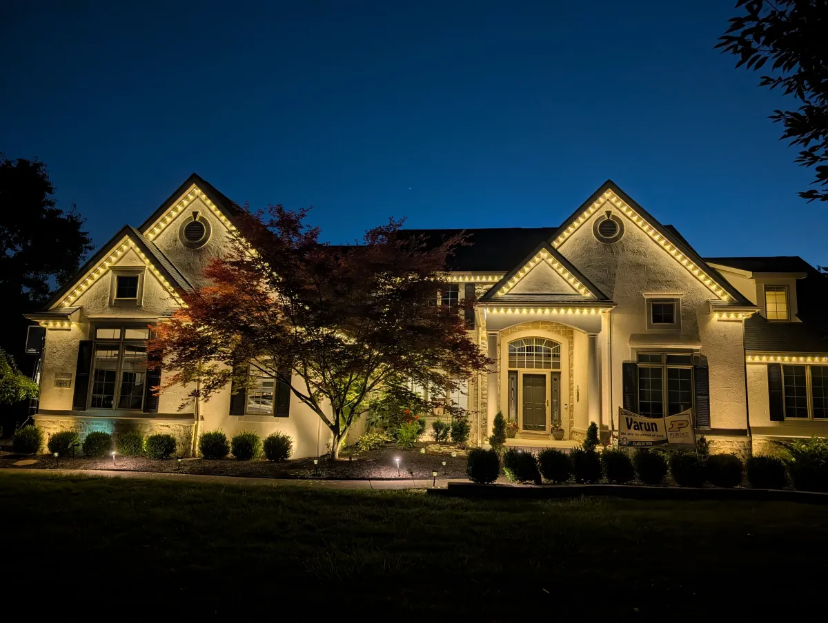 Warm white permanent accent lights on large estate home at dusk
