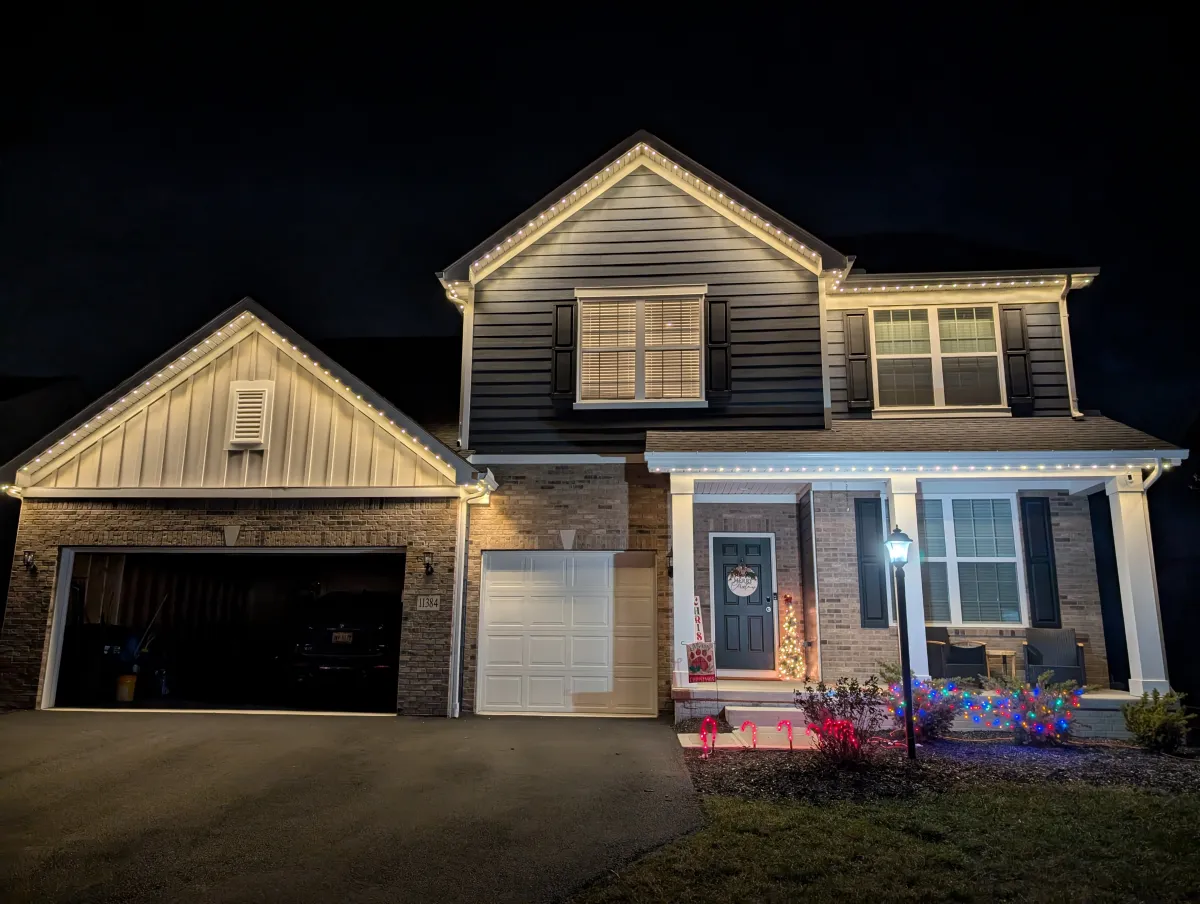 Warm white permanent lights on brick and stone home with Christmas decorations