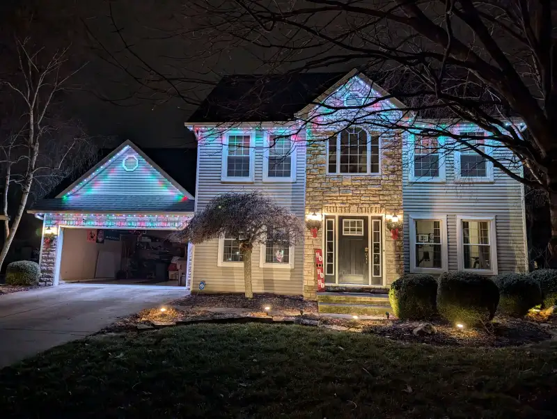 Warm white permanent lights on home during Christmas Eve