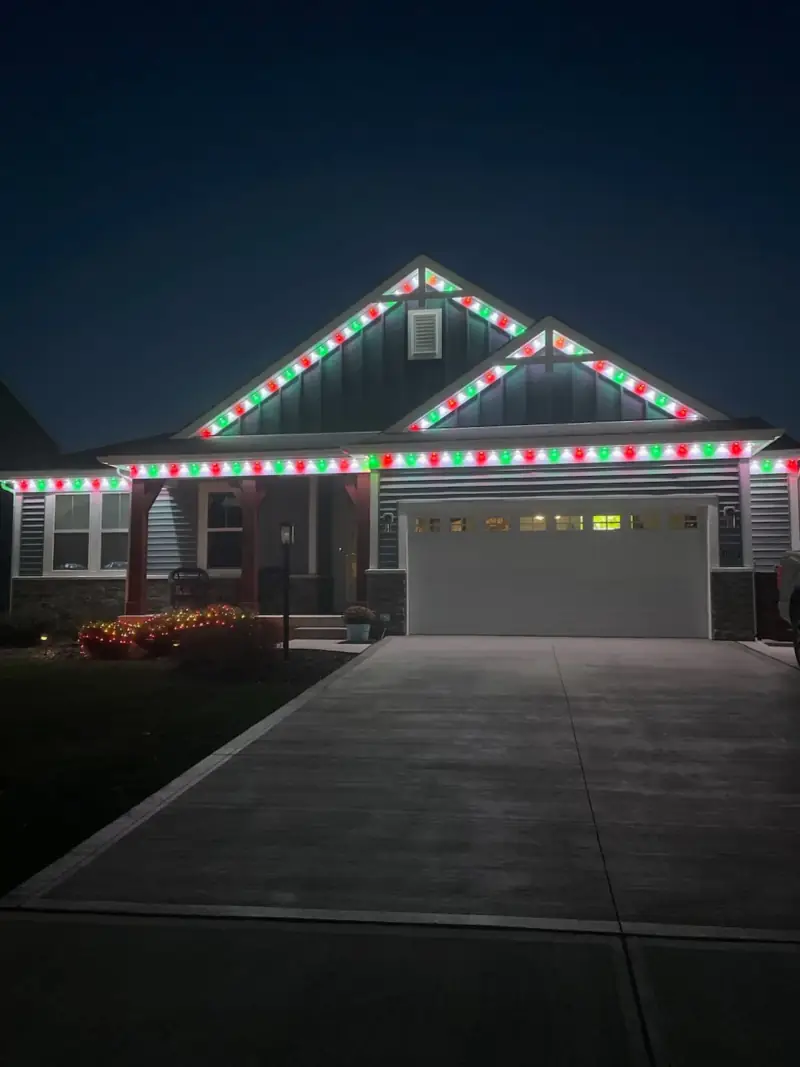 Red and green permanent Christmas lights on single story ranch home