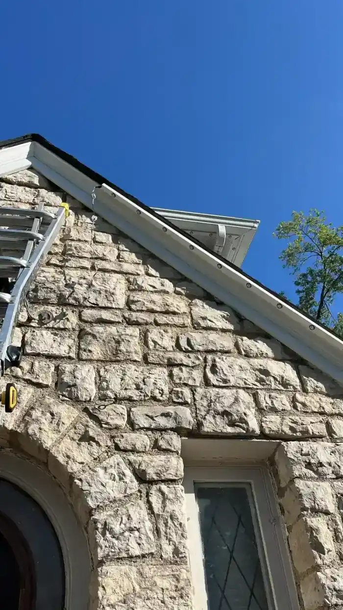 Daytime closeup of permanent light track mounted on white fascia board
