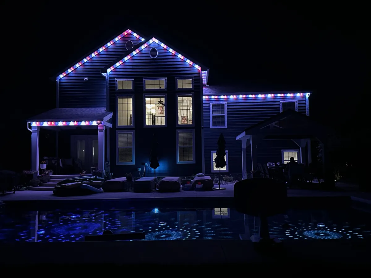 Red white and blue permanent lights from backyard pool view at night