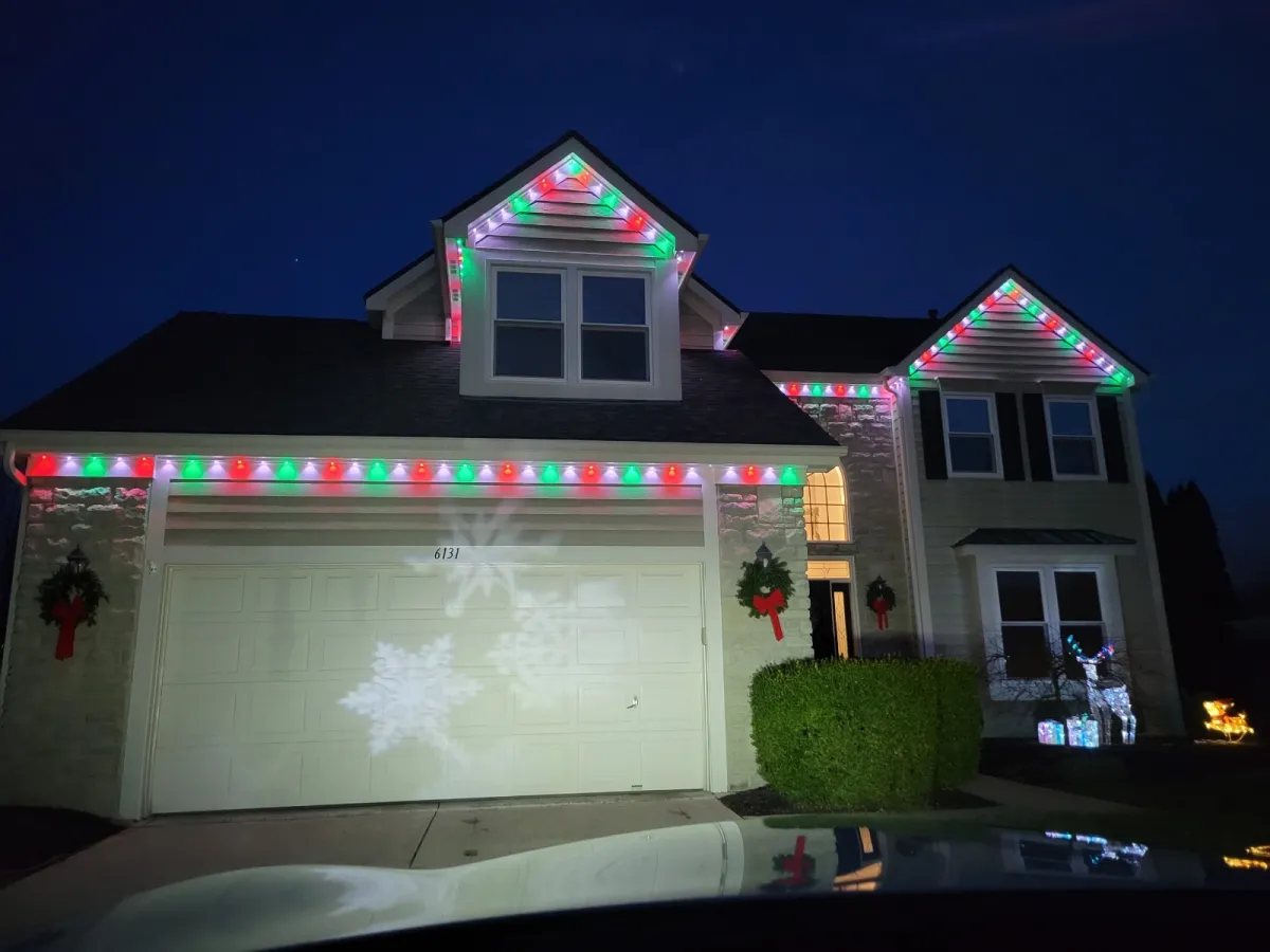 Green cone wash permanent lights on stone house at night